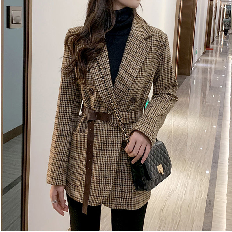 Women's houndstooth belted blazer worn with black trousers, full length