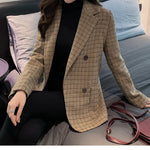 Women's houndstooth blazer worn open over a black turtleneck