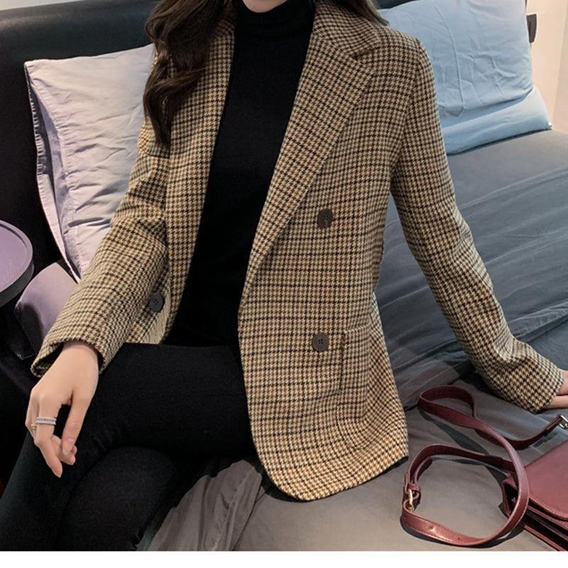 Women's houndstooth blazer worn open over a black turtleneck